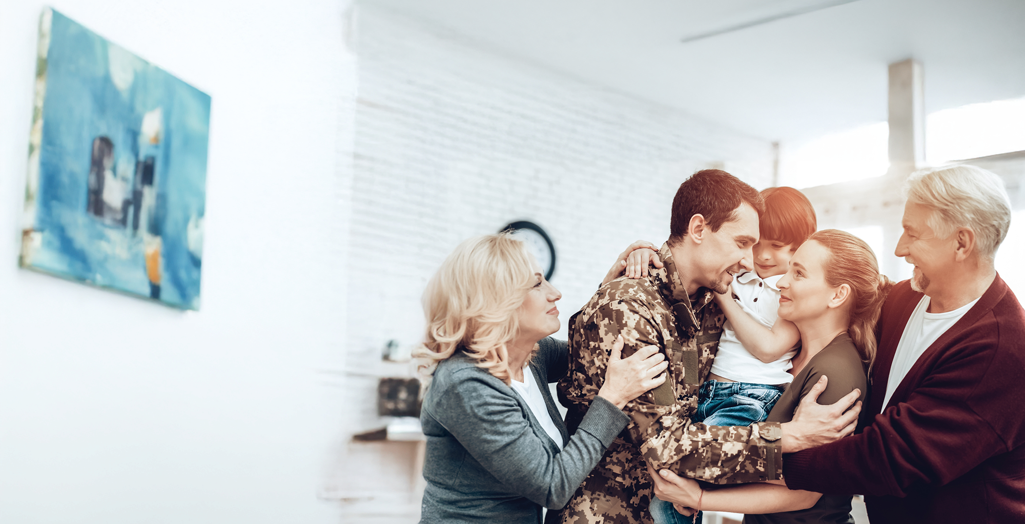 Child being hugged by their parents and grandparents