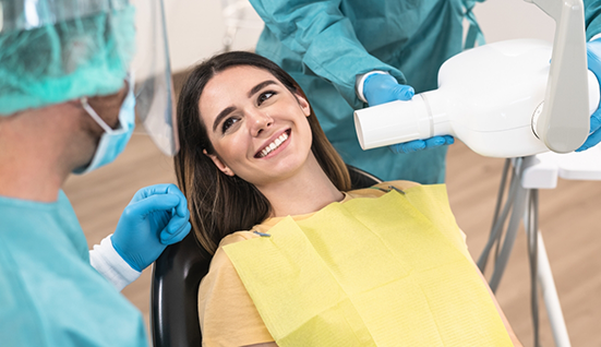 Woman in the dental chair grinning at her dentist