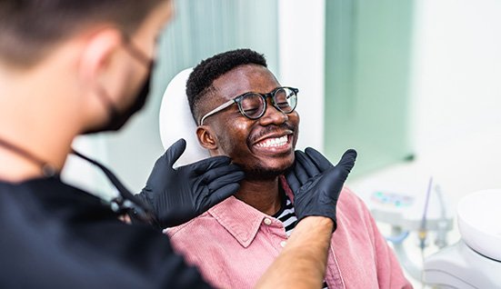 Dentist looking at patient's smile in treatment chair
