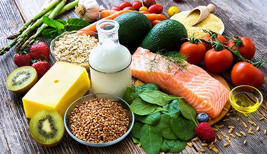 Variety of healthy foods gathered on a wooden surface