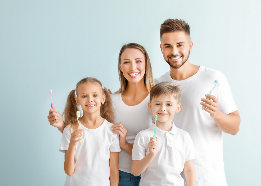 Family holding toothbrushes