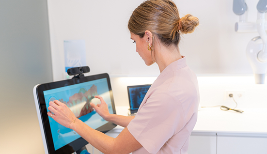Dentist touching a screen showing a digital impression of a patients teeth