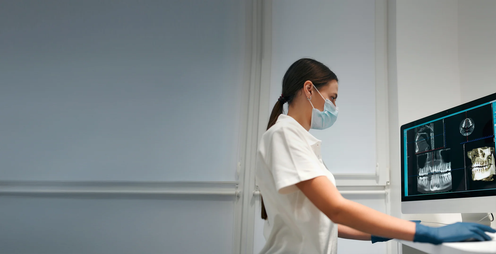 Dentist looking at x rays of teeth on a computer