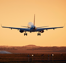Airplane taking off at sunset